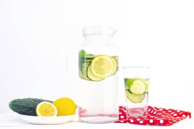 Sağlık hizmeti, fitness, sağlıklı beslenme konsepti. Taze soğuk limon salatalığı suyu, kokteyl, detoks içeceği, bardakta limonata ve bardakta. Bir tabakta salatalık ve limon