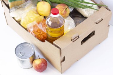 Bağış. Market kutusu, ihtiyacı olanlara yardım et. Bağış kutusu. Beyaz arka planda yiyecek gereksinimleri olan karton bir kutu..