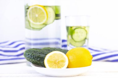 Sağlık hizmeti, fitness, sağlıklı beslenme konsepti. Taze soğuk limon salatalığı suyu, kokteyl, detoks içeceği, bardakta limonata ve bardakta. Bir tabakta salatalık ve limon
