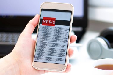 Bir cep telefonundan internet haberleri. Akıllı telefon ekran uygulamasında haber ya da makale okuyan iş kadınlarını kapatın. El ele tutuşan akıllı cihaz. Model web sitesi. Gazete.