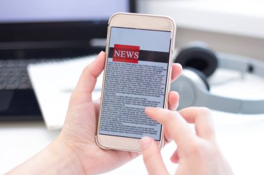 Bir cep telefonundan internet haberleri. Akıllı telefon ekran uygulamasında haber ya da makale okuyan iş kadınlarını kapatın. El ele tutuşan akıllı cihaz. Model web sitesi. Gazete.