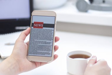 Bir cep telefonundan internet haberleri. Akıllı telefon ekran uygulamasında haber ya da makale okuyan iş kadınlarını kapatın. El ele tutuşan akıllı cihaz. Model web sitesi. Gazete.