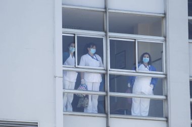 Yeni koronavirüs kriziyle ilgilenen sağlık çalışanları 26 Mart 2020 'de İspanya' nın kuzeybatısındaki Coruna Üniversitesi Hastanesi 'nin penceresinden baktılar.
