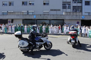 Bir Coruna-İspanya. Yeni koronavirüs kriziyle ilgilenen sağlık çalışanları, 26 Mart 2020 'de Sivil Muhafızlar ve diğer güvenlik güçleri tarafından hastanenin önünde alkışlanırken, buna karşılık alkış tutuyorlar.