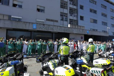 Bir Coruna-İspanya. Yeni koronavirüs kriziyle ilgilenen sağlık çalışanları, 26 Mart 2020 'de Sivil Muhafızlar ve diğer güvenlik güçleri tarafından hastanenin önünde alkışlanırken, buna karşılık alkış tutuyorlar.
