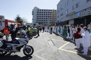 Bir Coruna-İspanya. Yeni koronavirüs kriziyle ilgilenen sağlık çalışanları, 26 Mart 2020 'de Sivil Muhafızlar ve diğer güvenlik güçleri tarafından hastanenin önünde alkışlanırken, buna karşılık alkış tutuyorlar.