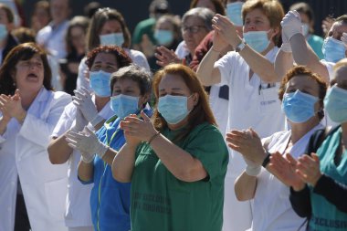 Bir Coruna-İspanya. Yeni koronavirüs kriziyle ilgilenen sağlık çalışanları, 26 Mart 2020 'de Sivil Muhafızlar ve diğer güvenlik güçleri tarafından hastanenin önünde alkışlanırken, buna karşılık alkış tutuyorlar.