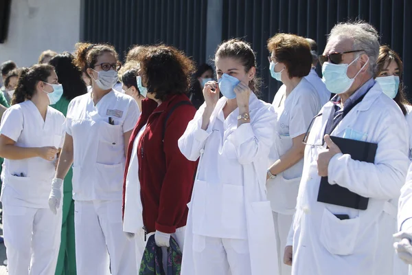 Bir Coruna-İspanya. Yeni koronavirüs kriziyle ilgilenen sağlık çalışanları, 26 Mart 2020 'de Sivil Muhafızlar ve diğer güvenlik güçleri tarafından hastanenin önünde alkışlanırken, buna karşılık alkış tutuyorlar.