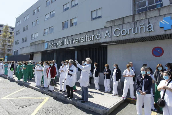 Bir Coruna-İspanya. Yeni koronavirüs kriziyle ilgilenen sağlık çalışanları, 26 Mart 2020 'de Sivil Muhafızlar ve diğer güvenlik güçleri tarafından hastanenin önünde alkışlanırken, buna karşılık alkış tutuyorlar.