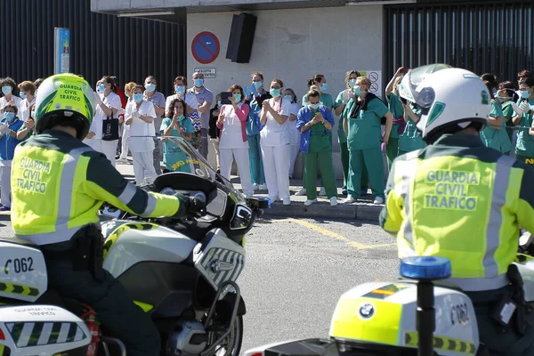 Bir Coruna-İspanya. Yeni koronavirüs kriziyle ilgilenen sağlık çalışanları, 26 Mart 2020 'de Sivil Muhafızlar ve diğer güvenlik güçleri tarafından hastanenin önünde alkışlanırken, buna karşılık alkış tutuyorlar.