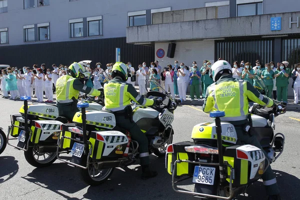 Bir Coruna-İspanya. Yeni koronavirüs kriziyle ilgilenen sağlık çalışanları, 26 Mart 2020 'de Sivil Muhafızlar ve diğer güvenlik güçleri tarafından hastanenin önünde alkışlanırken, buna karşılık alkış tutuyorlar.