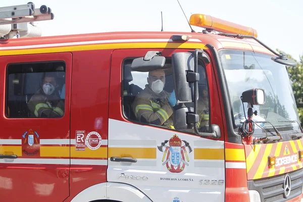 スペイン 3月にスペインに影響を与えるコロナウイルスのパンデミックの間に働く緊急サービスへのオマージュ中に消防車の中のマスクを持つ消防士26 2020 — ストック写真