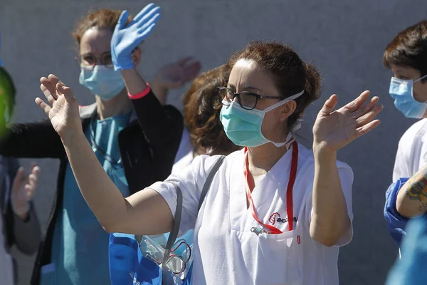 Bir Coruna-İspanya. Yeni koronavirüs kriziyle ilgilenen sağlık çalışanları, 26 Mart 2020 'de Sivil Muhafızlar ve diğer güvenlik güçleri tarafından hastanenin önünde alkışlanırken, buna karşılık alkış tutuyorlar.