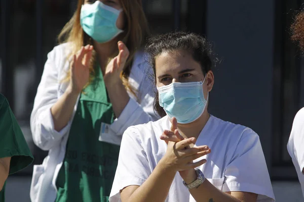 Bir Coruna-İspanya. Yeni koronavirüs kriziyle ilgilenen sağlık çalışanları, 26 Mart 2020 'de Sivil Muhafızlar ve diğer güvenlik güçleri tarafından hastanenin önünde alkışlanırken, buna karşılık alkış tutuyorlar.