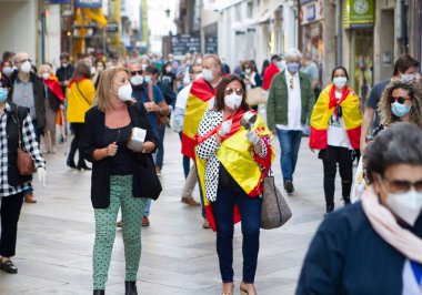 Coruna-İspanya. 19 Mayıs 2020 'de İspanyol hükümetinin yönetimine karşı yüz maskeli protestocular bir tencereye dokundular.