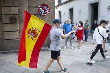 Coruna-İspanya. 19 Mayıs 2020 'de İspanyol hükümetinin yönetimine karşı yüz maskeli protestocular bir tencereye dokundular.