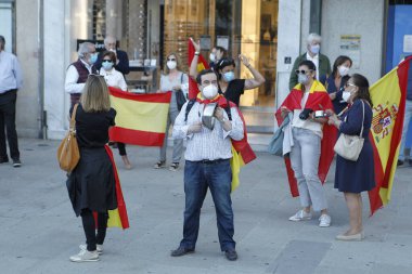 Coruna-İspanya. 19 Mayıs 2020 'de İspanyol hükümetinin yönetimine karşı yüz maskeli protestocular bir tencereye dokundular.