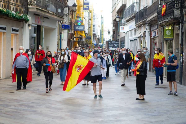 Coruna-İspanya. 19 Mayıs 2020 'de İspanyol hükümetinin yönetimine karşı yüz maskeli protestocular bir tencereye dokundular.