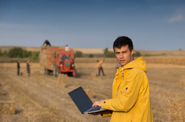 Agricultor en campo con tractor en segundo plano —  Fotos de Stock