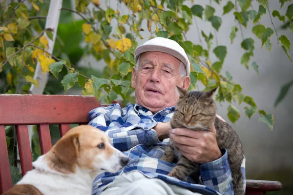 Starší muž s domácími mazlíčky — Stock fotografie