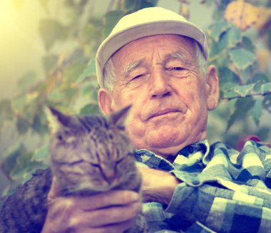 Yaşça daha büyük kedi avluda adamla