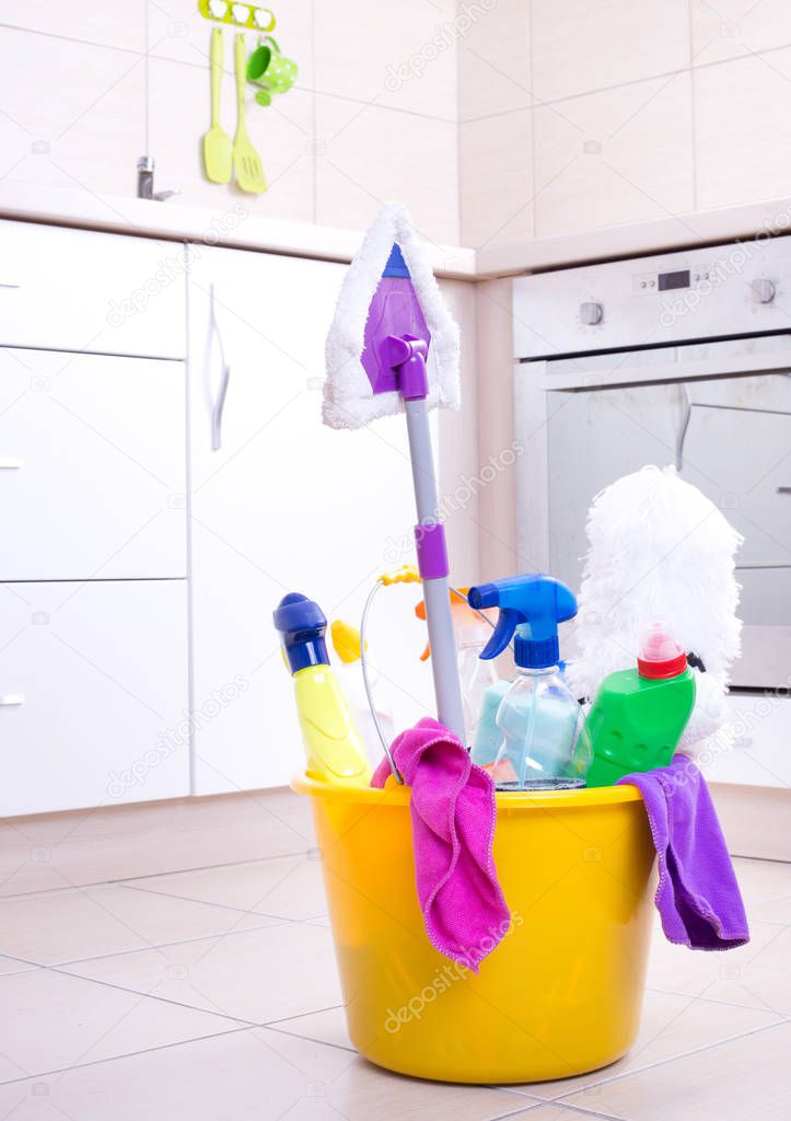 Cleaning supplies in bucket on kitchen floor