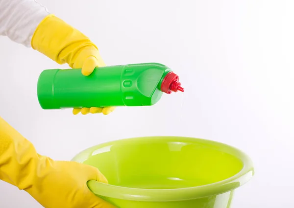 Mujer vertiendo detergente en lavabo sobre fondo blanco —  Fotos de Stock