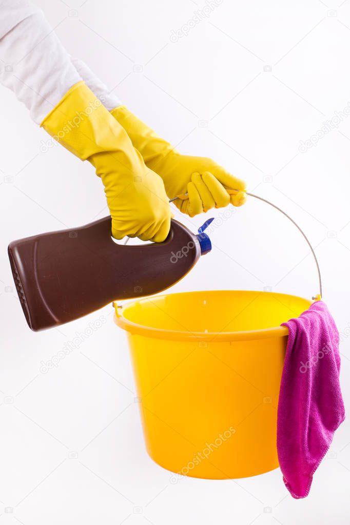 Woman pouring detergent into bucket on white background