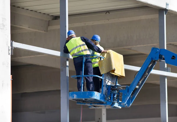 Trabajadores de la construcción en jaula elevadora —  Fotos de Stock