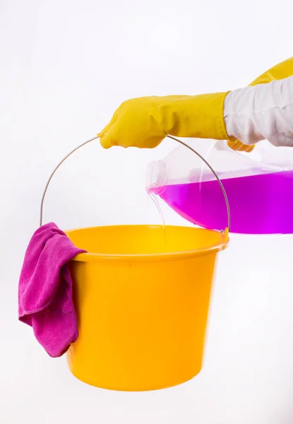 Woman pouring detergent into bucket on white background — Stock Photo, Image