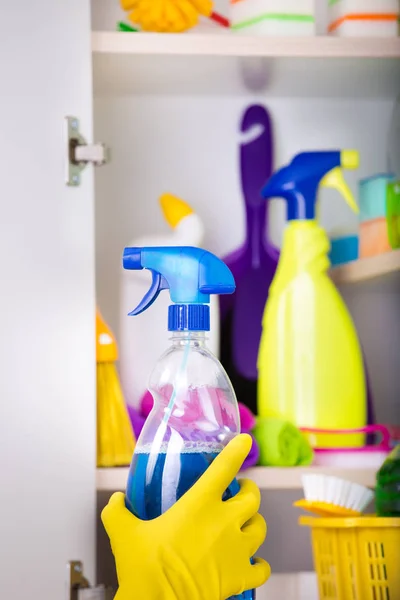 Mujer poniendo aerosol botella en despensa — Foto de Stock