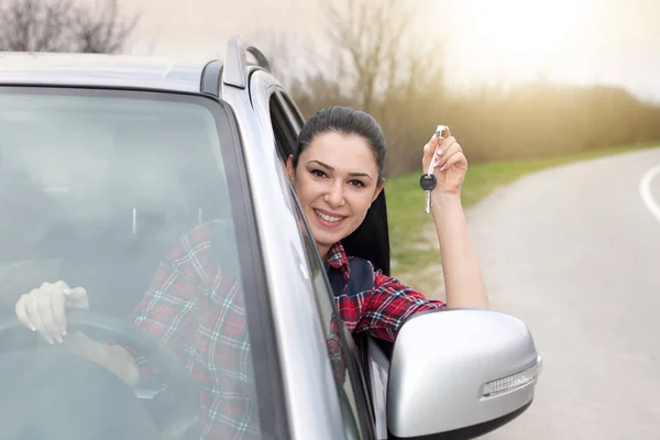 Frau fährt Auto und zeigt Schlüssel — Stockfoto