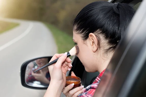 Mädchen schminkt sich im Auto — Stockfoto
