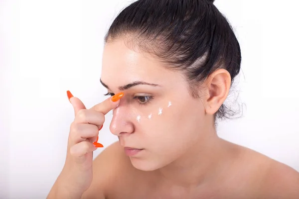 Menina aplicando creme facial — Fotografia de Stock