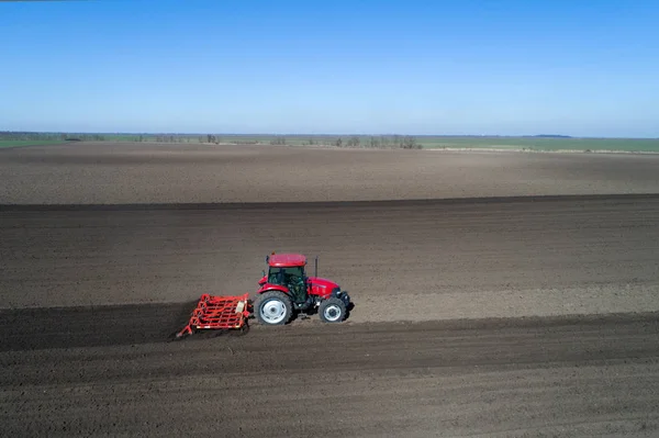 Tractor harrowing soil in spring — Stock Photo, Image