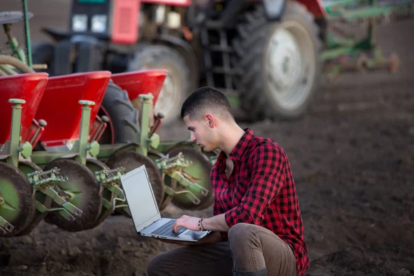 Agricultor com laptop e tratores — Fotografia de Stock