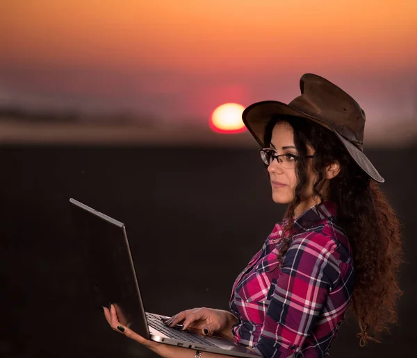 Kvinna med laptop i fältet — Stockfoto