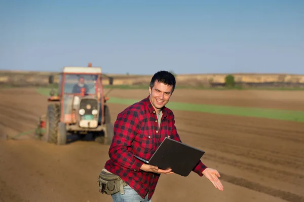 Spokojený farmář s notebookem a traktor — Stock fotografie