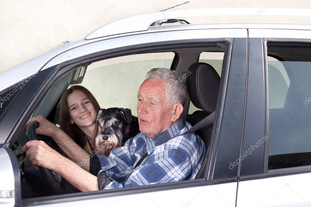 Granfather, grandchild and dog in car