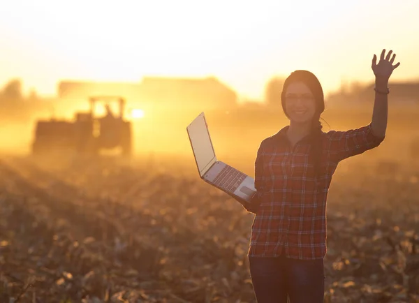 Kobieta z laptopa przed ciągnika — Zdjęcie stockowe