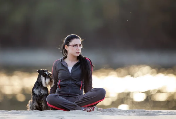 Девушка с собакой на берегу реки — стоковое фото