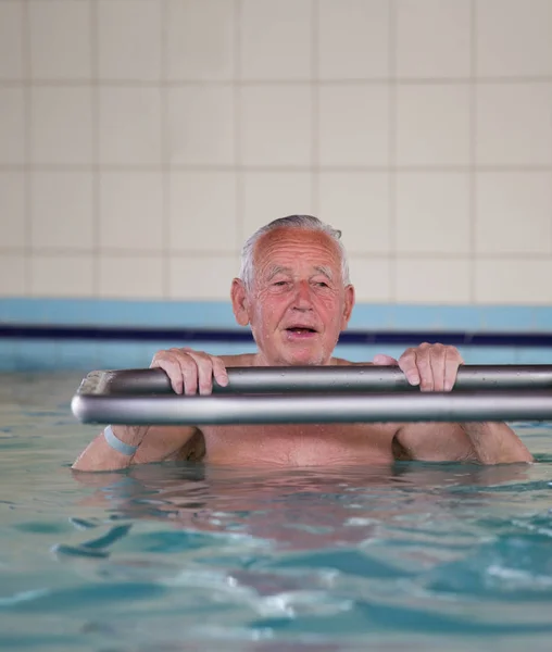 Senior man i poolen — Stockfoto