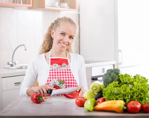 Mulher cortando vegetais na cozinha — Fotografia de Stock