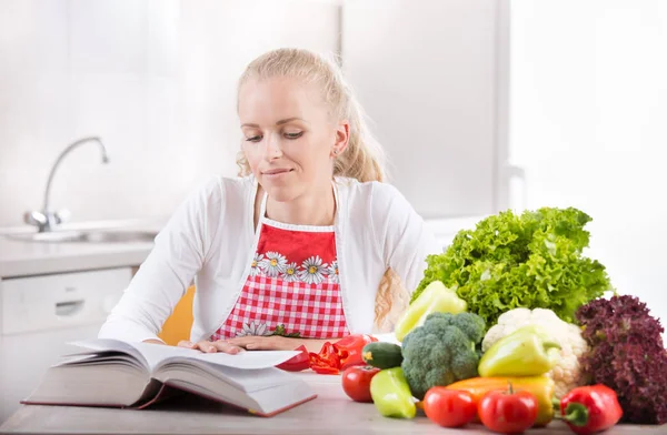 Mulher leitura livro de receitas — Fotografia de Stock