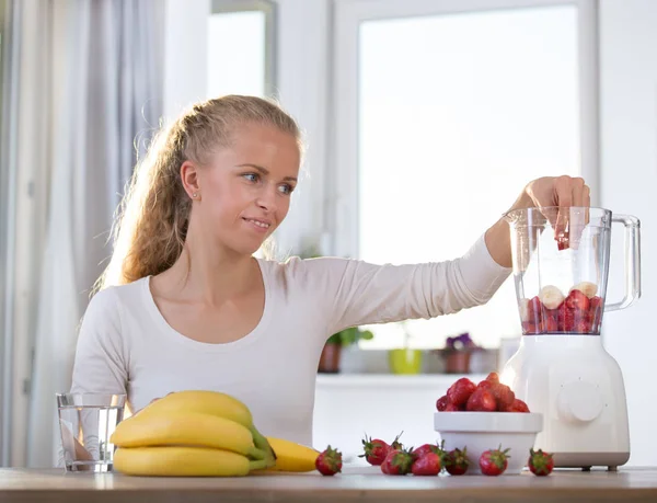 Mulher preparando smoothie no liquidificador — Fotografia de Stock