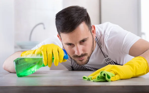 Homem limpando mesa de cozinha — Fotografia de Stock