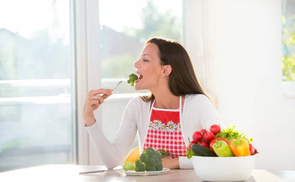 Kvinna äta broccoli — Stockfoto