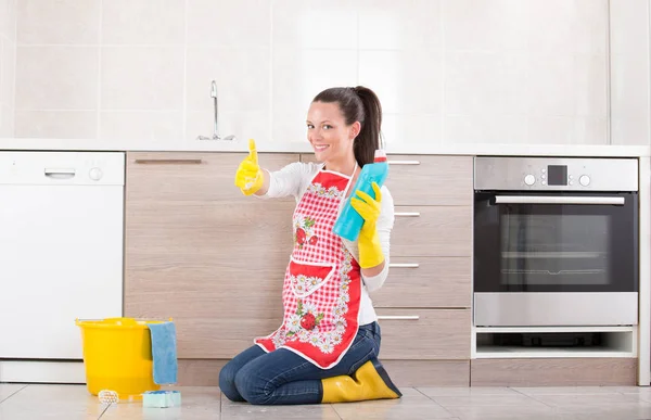 Limpeza senhora mostrando garrafa e polegar para cima — Fotografia de Stock