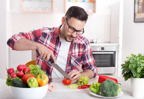 Man hugga grönsak i kök — Stockfoto