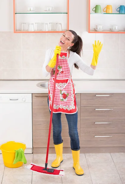 Limpeza senhora cantando na cozinha — Fotografia de Stock